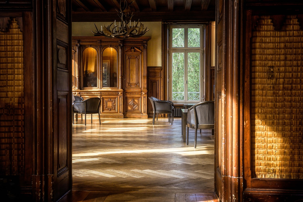 A sunlit salon room with wooden floors and a chair