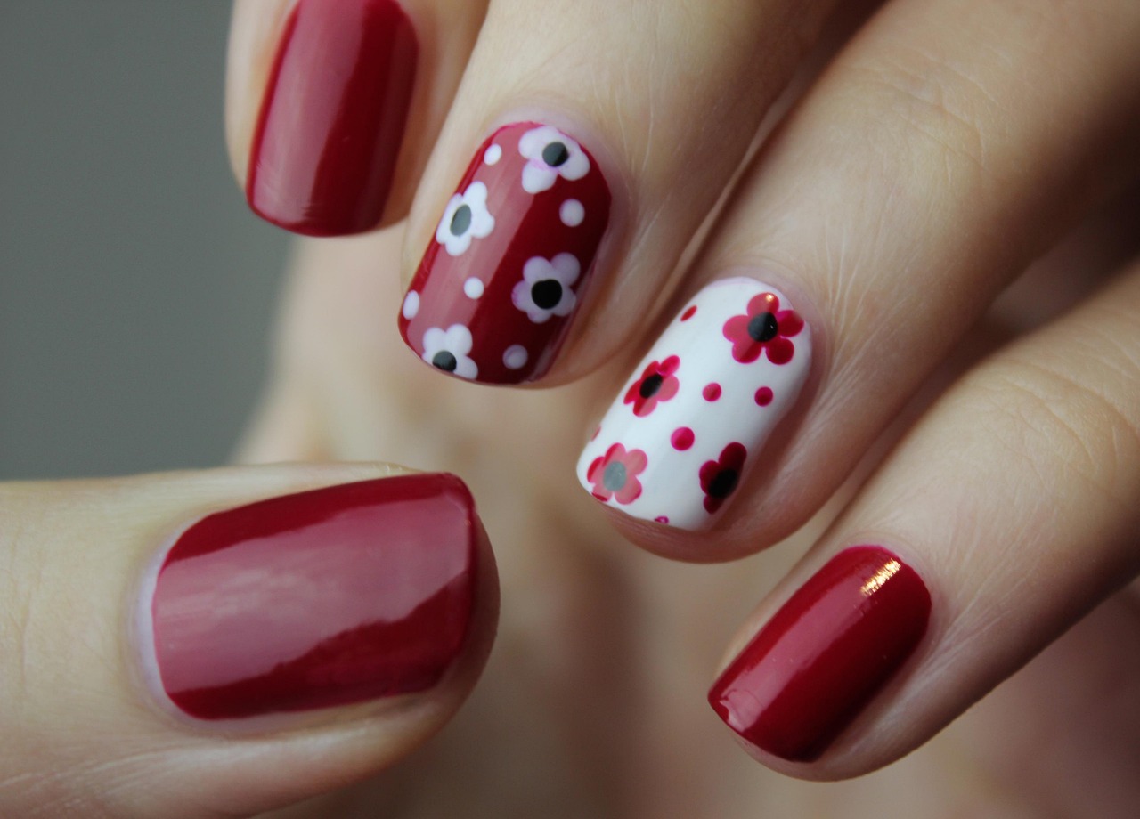 Hand-painted floral nail art in red